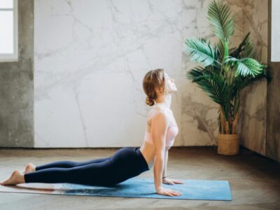 Frau bei einer Pilates- bzw. Yoga-Übung auf der Matte